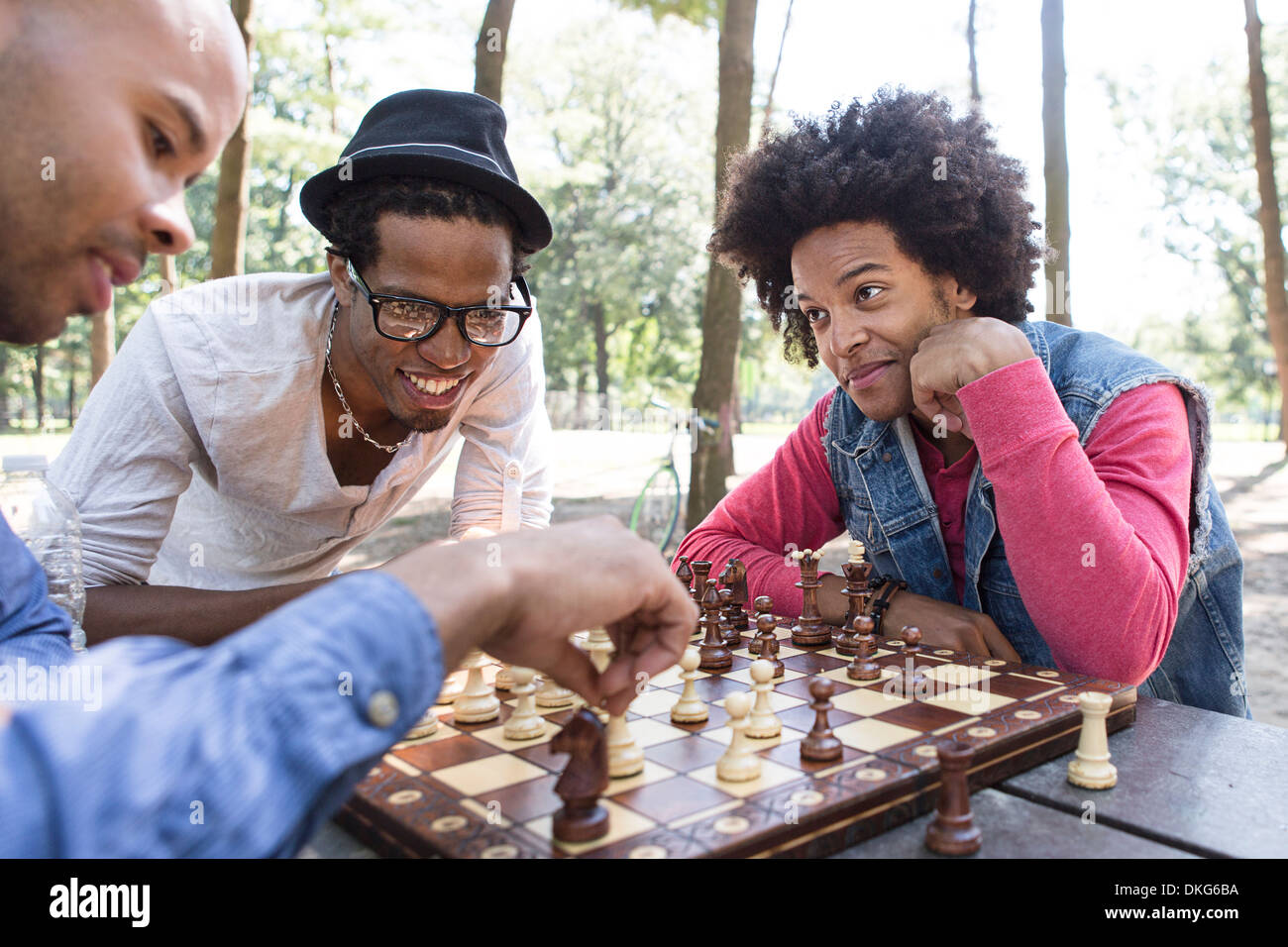 Drei junge Männer spielen Schach im park Stockfoto