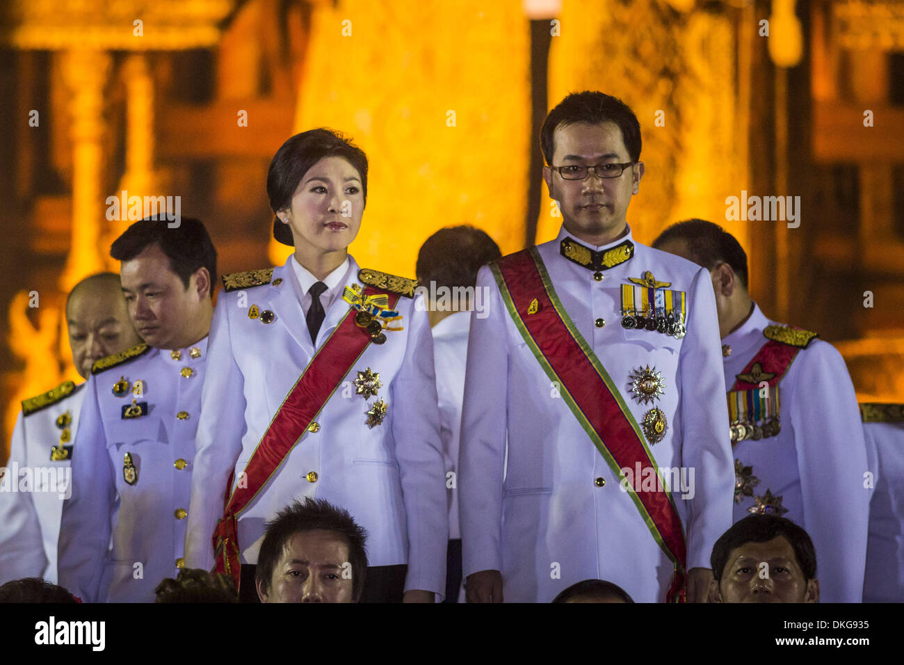 Bangkok, Thailand. 5. Dezember 2013. YINGLUCK SHINAWATRA (Mitte) Premierminister von Thailand und ANUSORN AMORNCHAT, ihr Ehemann, (rechts) auf der Bühne die Feier des Geburtstages des Königs in Bangkok. Thais beobachtet der 86. Geburtstag von Bhumibol Adulyadej, der König von Thailand, ihrer verehrten Königs am Donnerstag. Sie hielten Candle-Light-Service im ganzen Land. Die politische Proteste, die Bangkok gegriffen haben waren auf Eis für den Tag, obwohl Demonstranten eigene Gedenktage des Urlaubs zu halten. Tausende von Menschen besuchten die Regierung Feier des Tages am Sanam Luang, das l Stockfoto