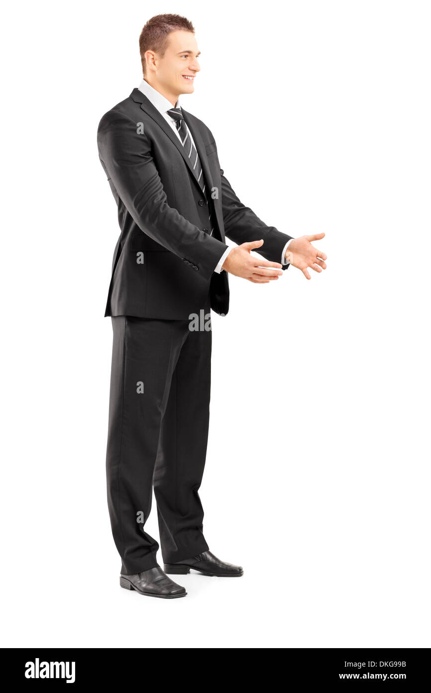 In voller Länge Portrait eines lächelnden Geschäftsmann im Anzug etwas nehmen Stockfoto