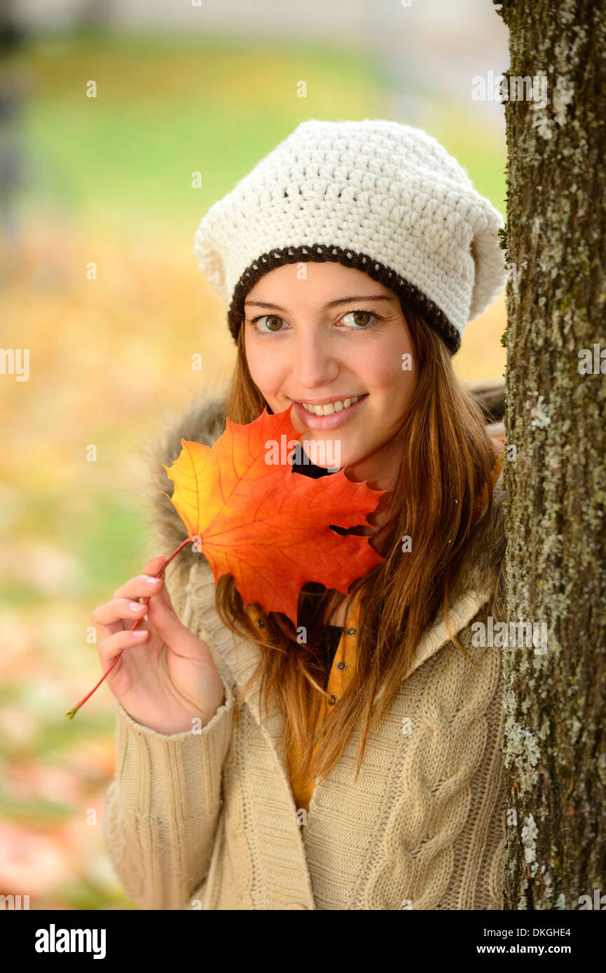 Lächelnde junge Frau Holding Herbst Blatt, Porträt Stockfoto