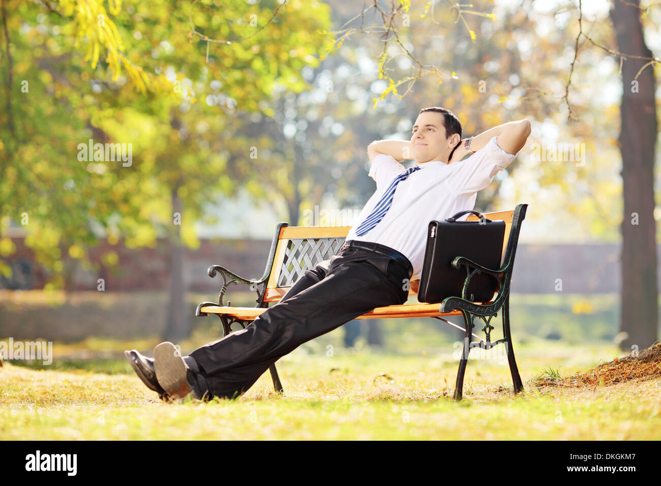 Junge Unternehmer auf einer Bank sitzen und entspannen in einem park Stockfoto