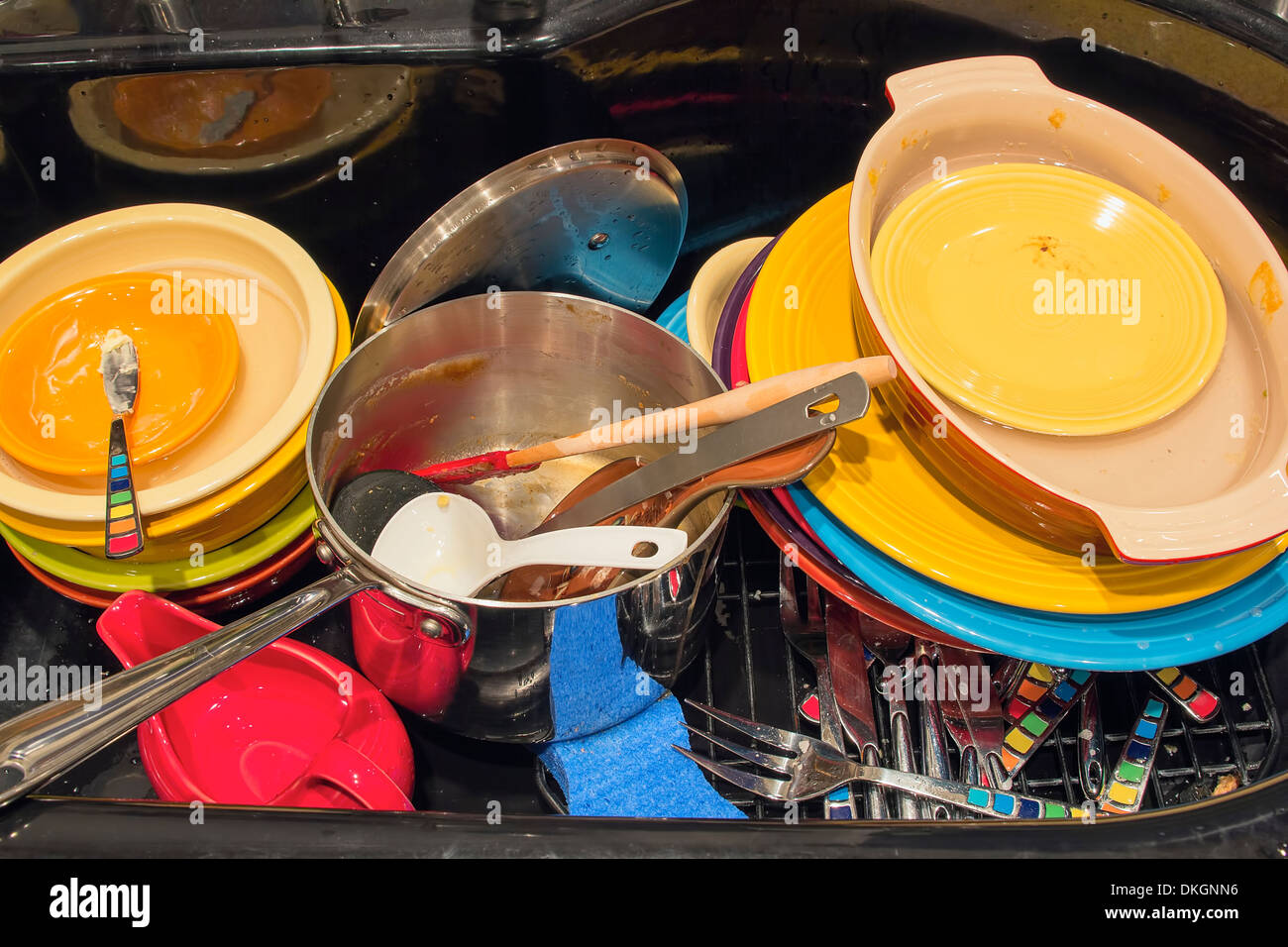 Spüle und Wasserhahn bunte schmutziges Geschirr Geschirr Post Schalen Platten nach dem Urlaub Essen Stockfoto