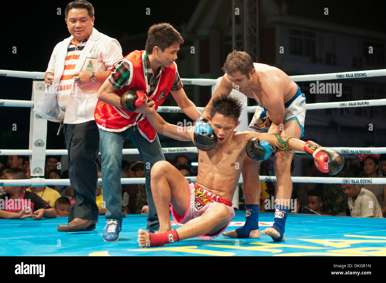 Thai-Boxer helfen, seinen Gegner zu seinen Füßen nach Knock-out des Königs Geburtstag Max Muay Thai Krieger kämpfen 2013 Stockfoto