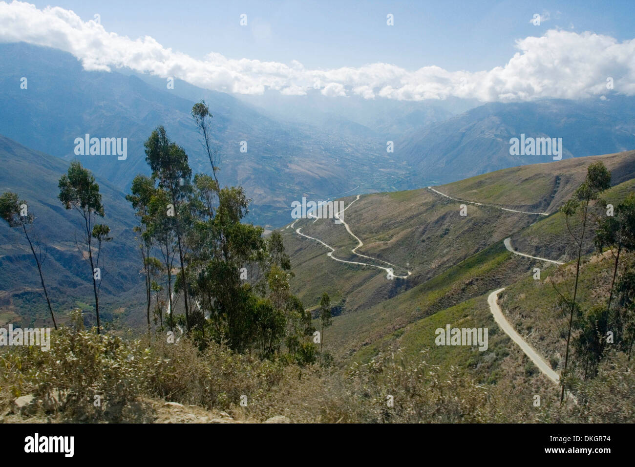 Hohe schmale kurvenreiche Straße durch die Anden in Peru mit Schnee bedeckt Gipfeln, tiefen Tälern und kargen Hügeln überragt Stockfoto