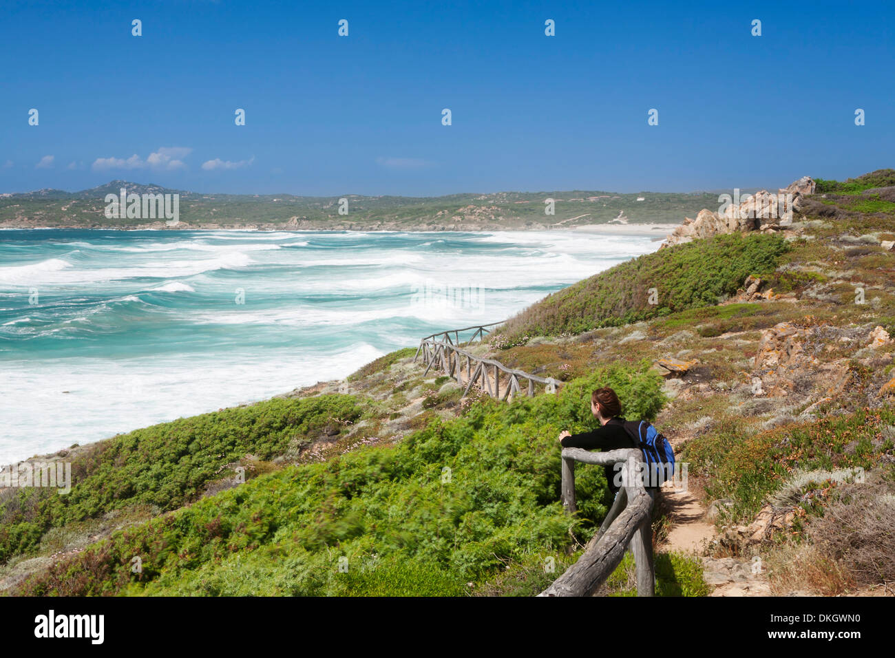 Frau an einem Pfad entlang der Westküste am Strand von Rena Maiore, Sardinien, Italien Stockfoto