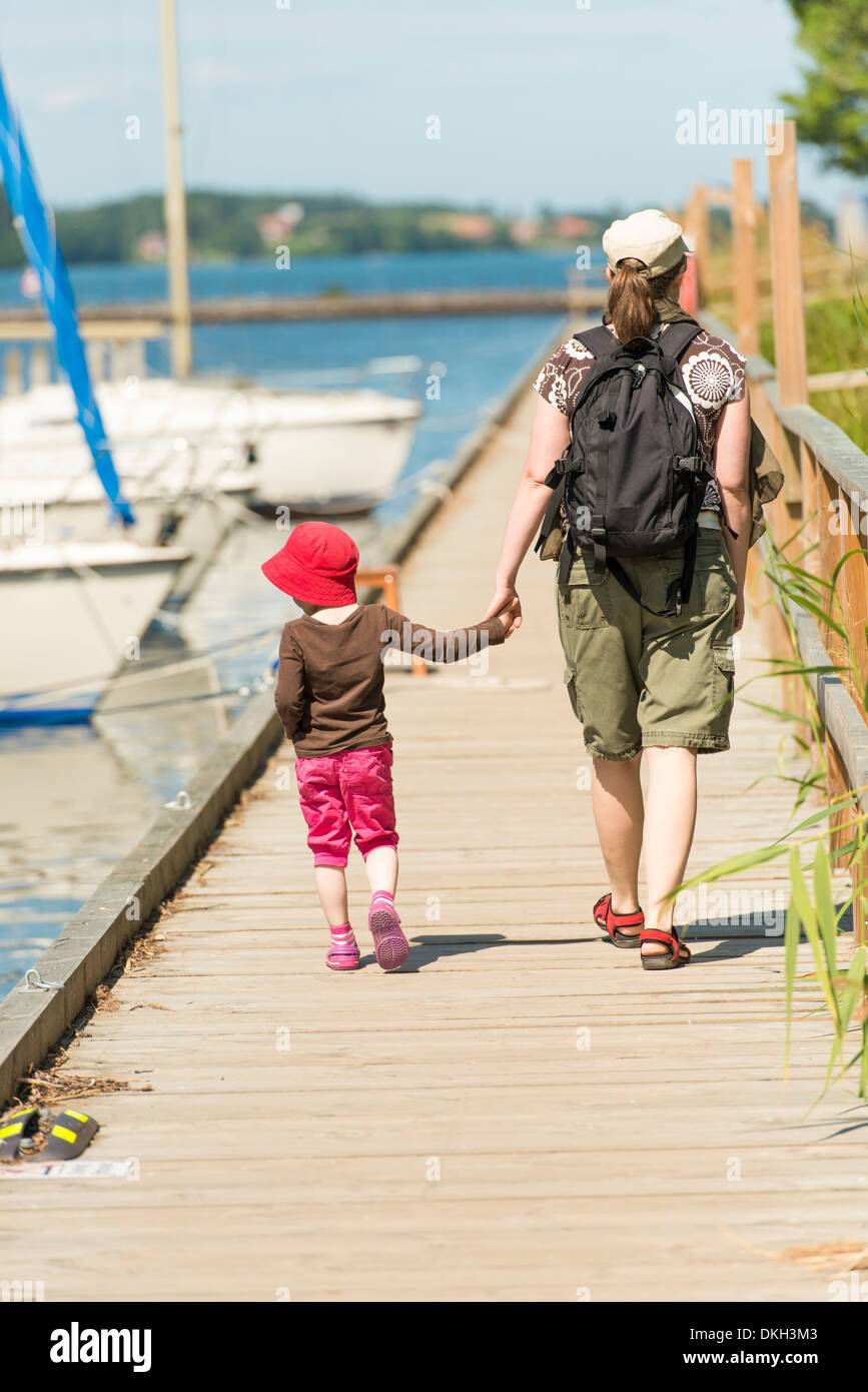 Mutter und Kind Blick auf Segelbooten, zu Fuß am Steg an sonnigen Sommertag. Schweden. Stockfoto