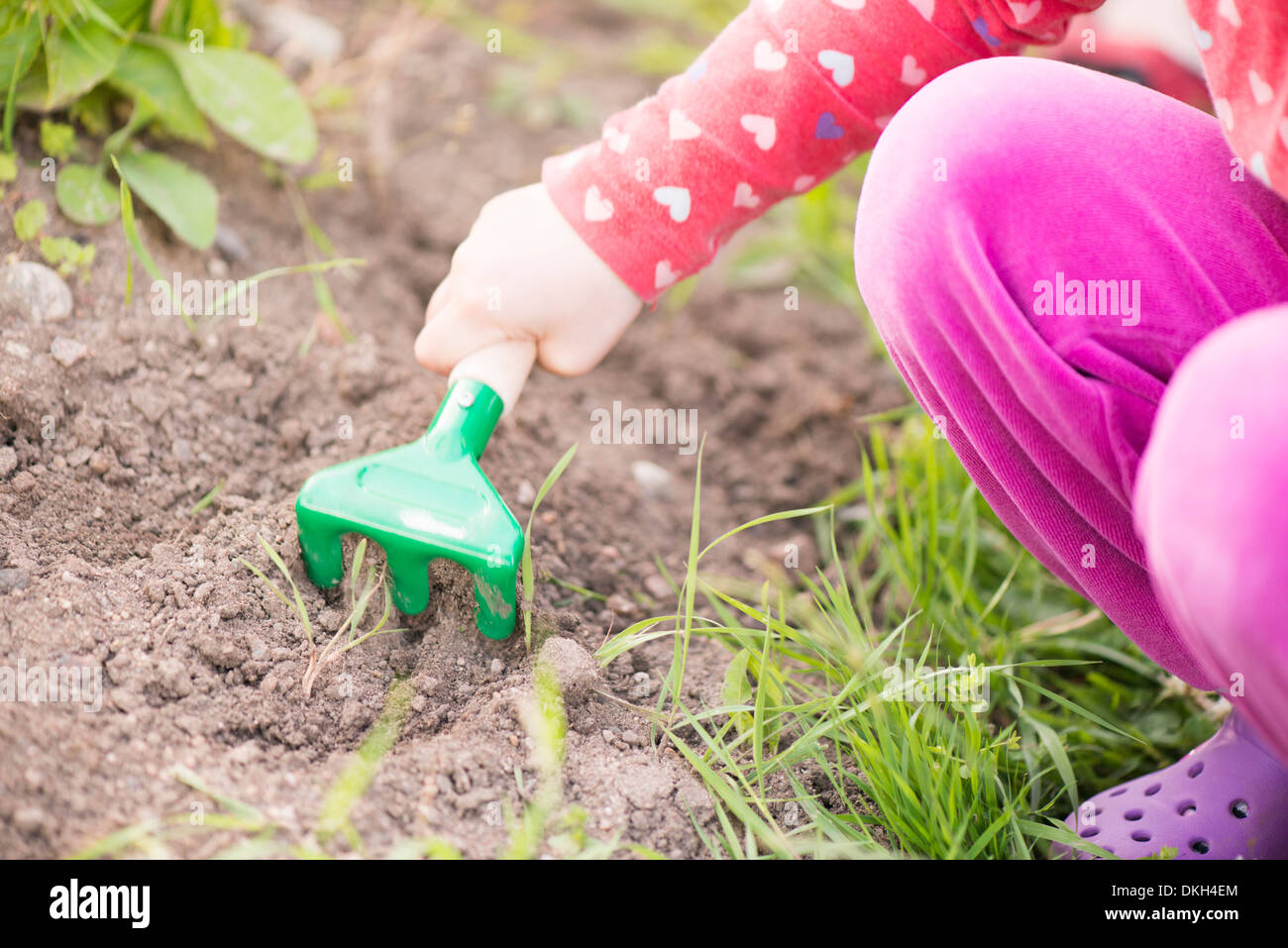 Nahaufnahme des jungen Kind im Garten mit Pflanzen und Blumen zu helfen, in den Boden graben. Stockfoto