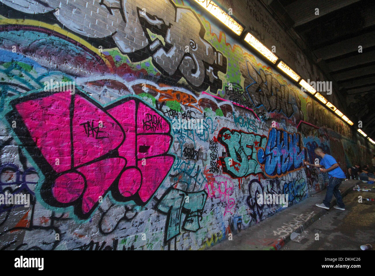 Junge Erwachsene männliche Graffiti-Künstler Malerei in Waterloo Tunnel London Stockfoto