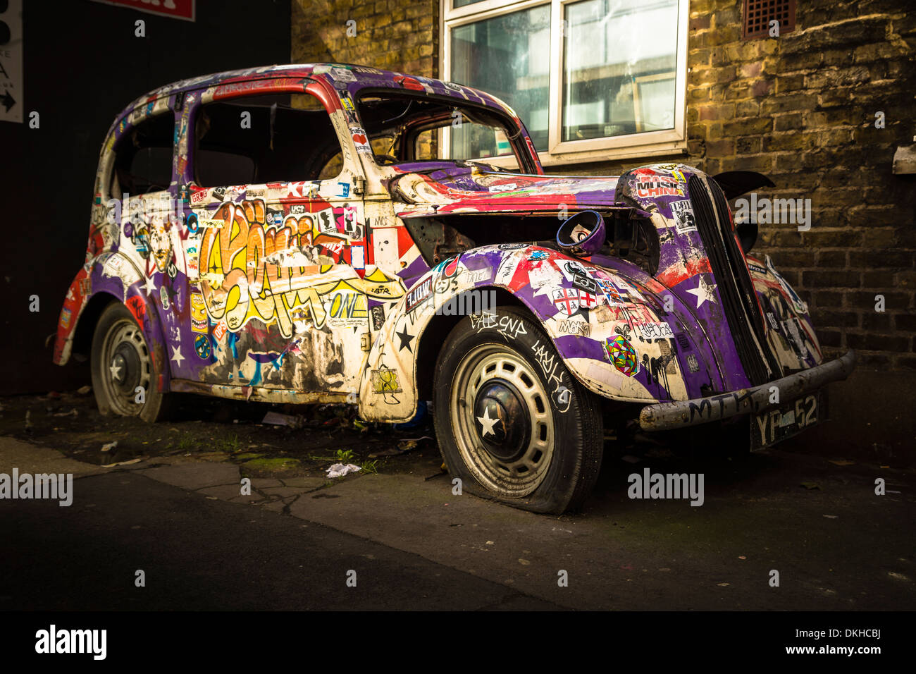 Ein altes verlassenes Auto, Graffiti, bedeckt ist eine regelmäßige Attraktion für die Besucher der Camden Lock Village Market in London. Stockfoto