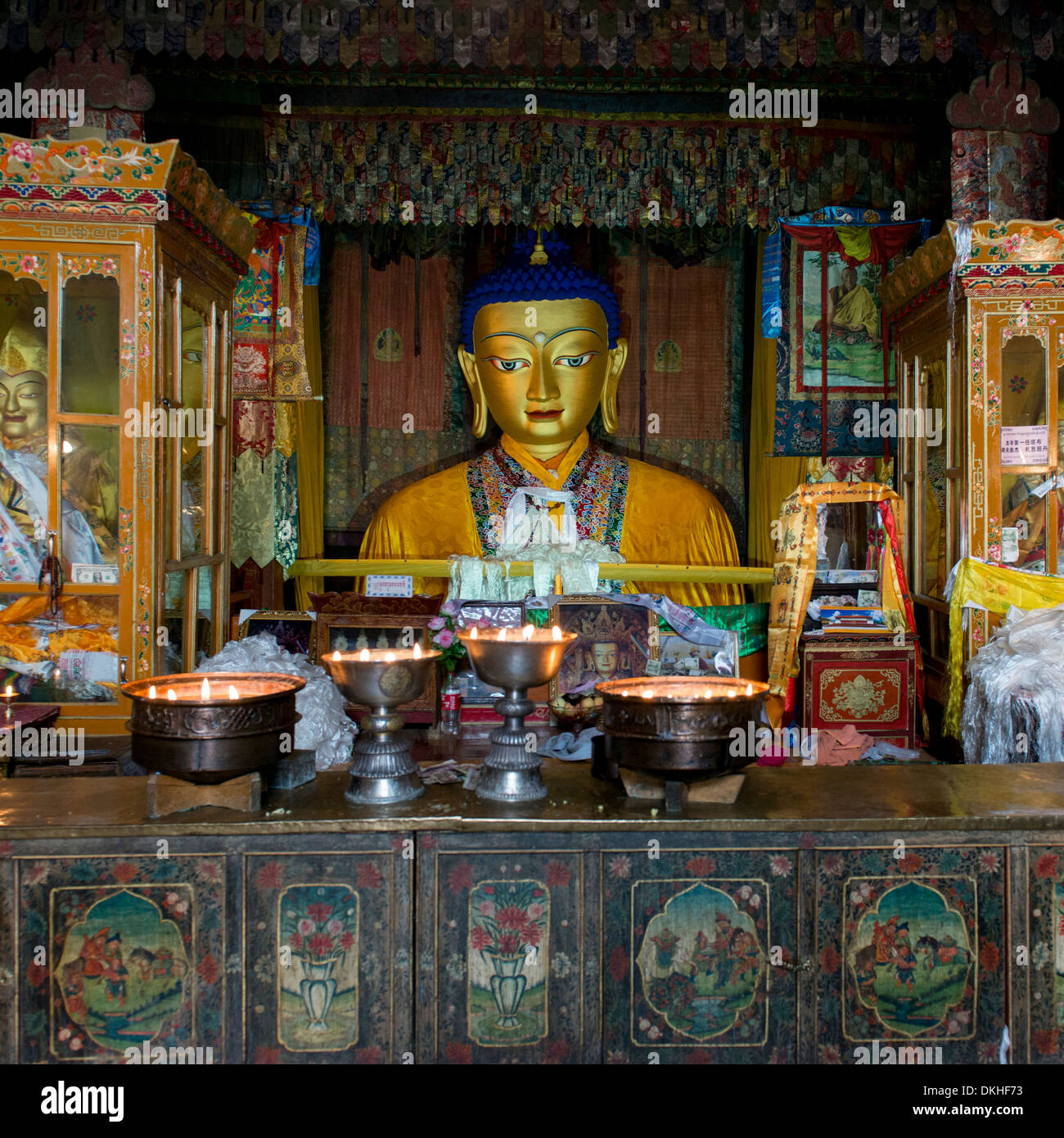 Votiv-Kerzen brennen vor Buddha-Statue im Kloster Drepung, Lhasa, Tibet, China Stockfoto