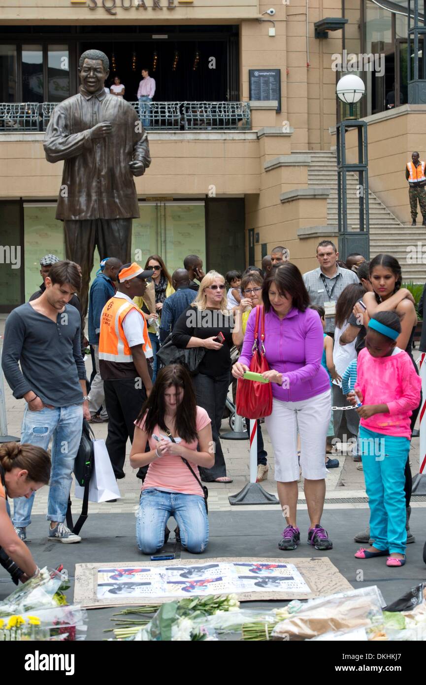 JOHANNESBURG, Südafrika: Menschen versammeln, um Tribut zollen Madiba am Nelson Mandela Square, am 6. Dezember 2013 in Houghton, Johannesburg, Südafrika. Trauernde haben seit den frühen Stunden des morgens ihre Aufwartung eingeholt. Der Vater der Nation, Nelson Mandela, Tata Madiba, ruhig am Abend des 5. Dezember 2013 in seinem Haus in Houghton mit Familie verstorben. (Foto von Gallo Images / Foto24 / Nicolene Olckers) Stockfoto