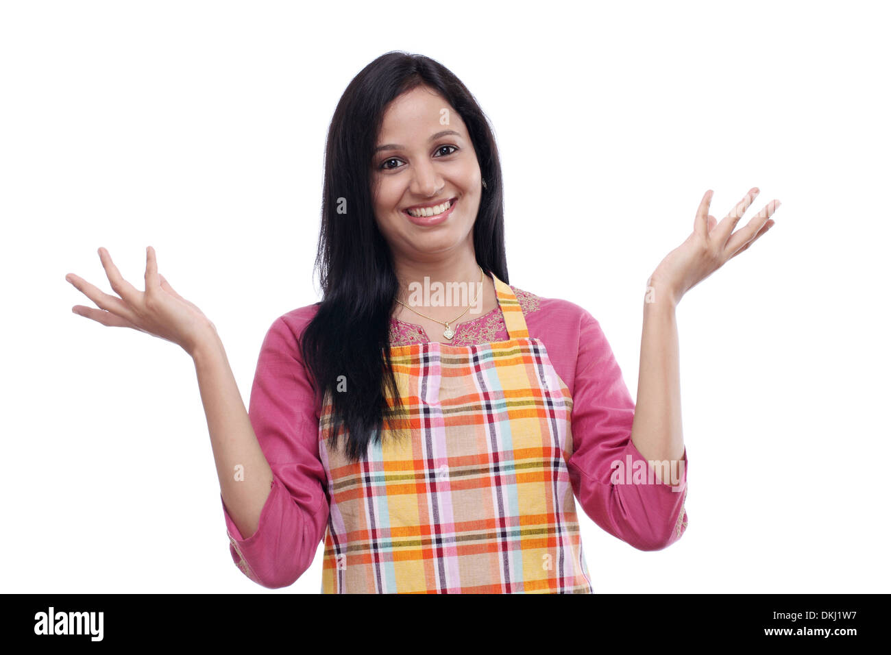 Begeistert junge Frau trägt Küchenschürze vor weißem Hintergrund Stockfoto