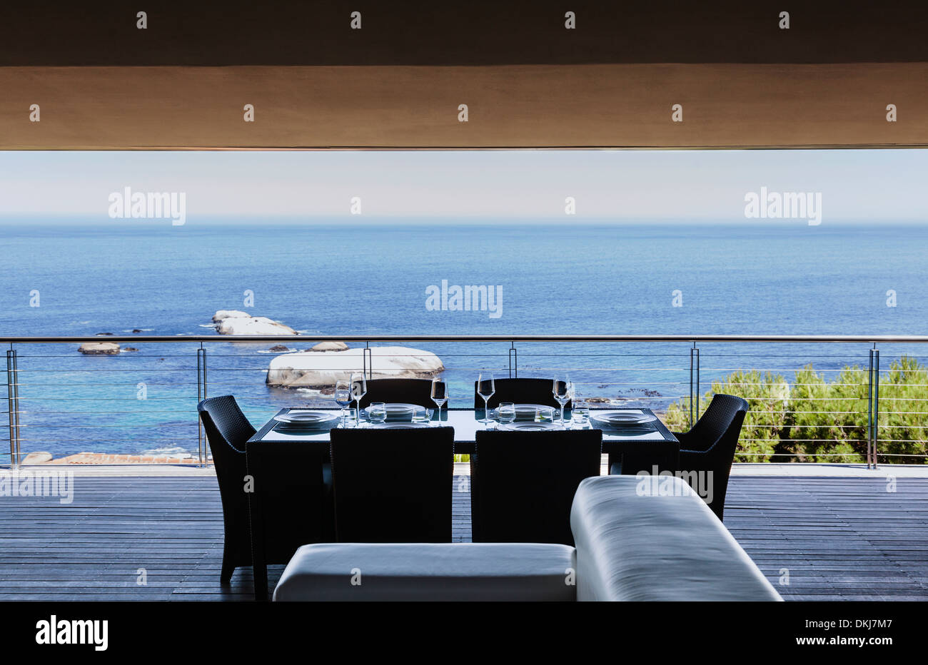 Esstisch auf Luxus-Balkon mit Blick auf Meer Stockfoto