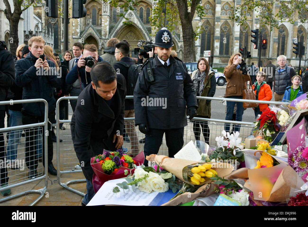 London, UK. 6. Dezember 2013. Trauernde lassen Sie Blumen und Nachrichten am Fuße des Nelson Mandela Statue in Parliament Square, London. Nelson Mandela, starb am 5. Dezember 2013 nach einem langen Kampf mit seiner Gesundheit erster schwarzer Präsident Südafrikas. Bildnachweis: Patricia Phillips/Alamy Live-Nachrichten Stockfoto