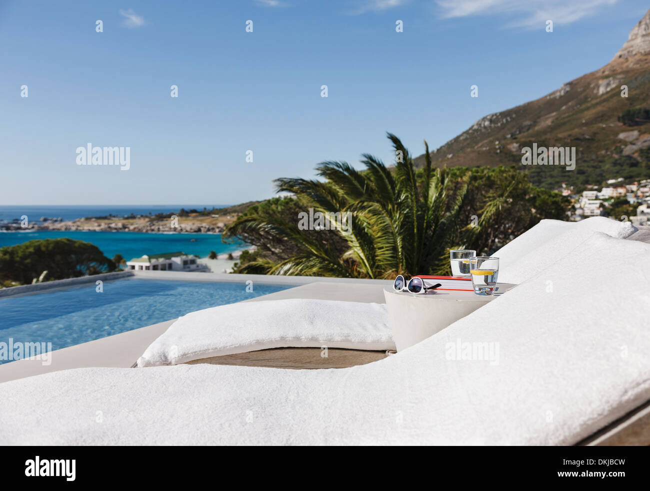 Liegestühlen und Pool mit Blick auf Meer Stockfoto