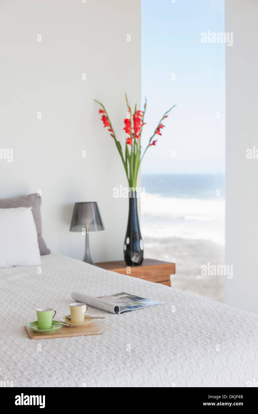 Frühstückstablett auf Bett in modernen Schlafzimmer mit Meerblick Stockfoto