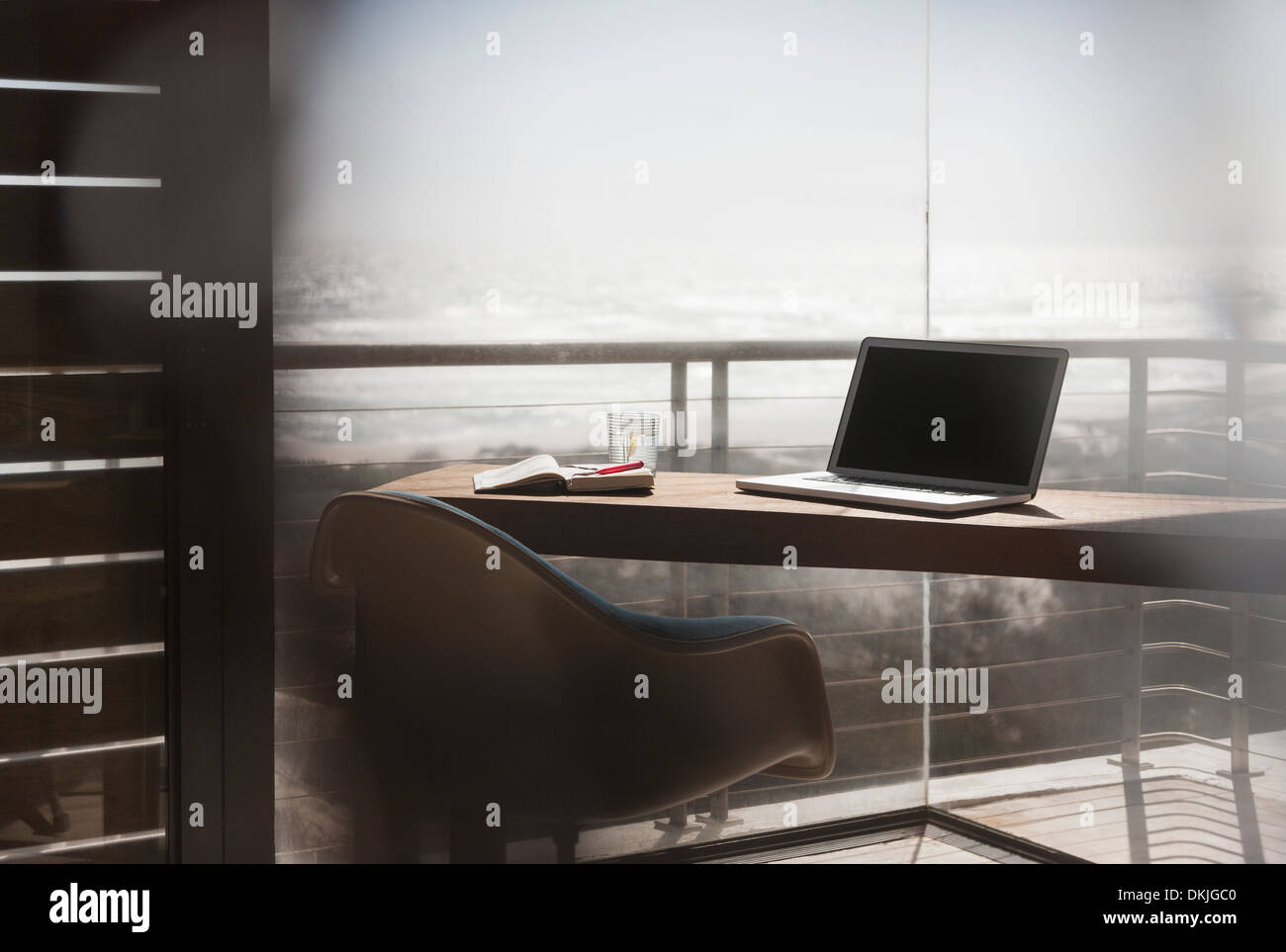 Laptop am Schreibtisch im modernen home-Office mit Blick auf Meer Stockfoto