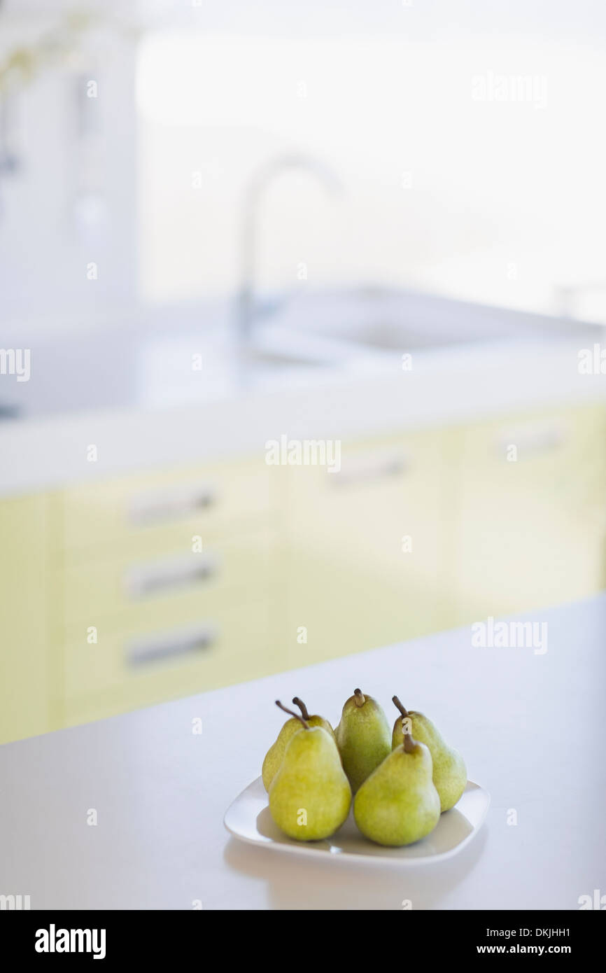 Teller mit Birnen auf Küchentisch Stockfoto