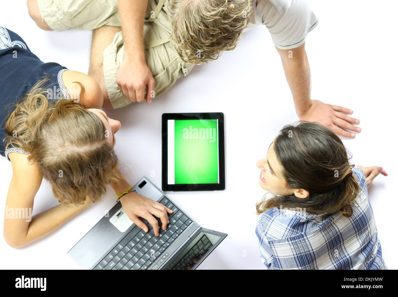 Eine Gruppe junger Studenten, die mit einem Laptop und einem elektronischen tablet Stockfoto