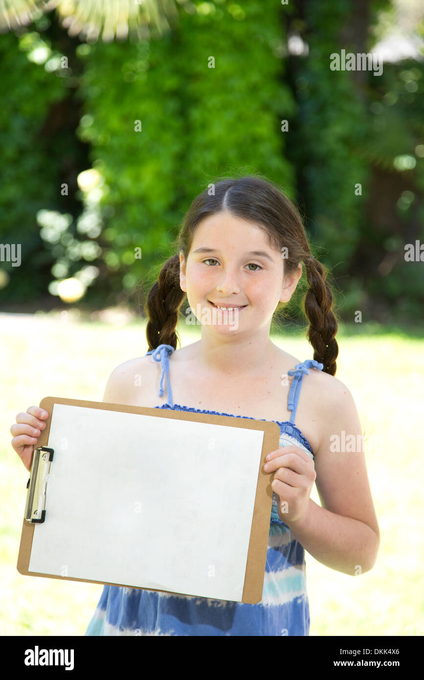 Junges Mädchen hält Zwischenablage mit leerem Papier Stockfoto