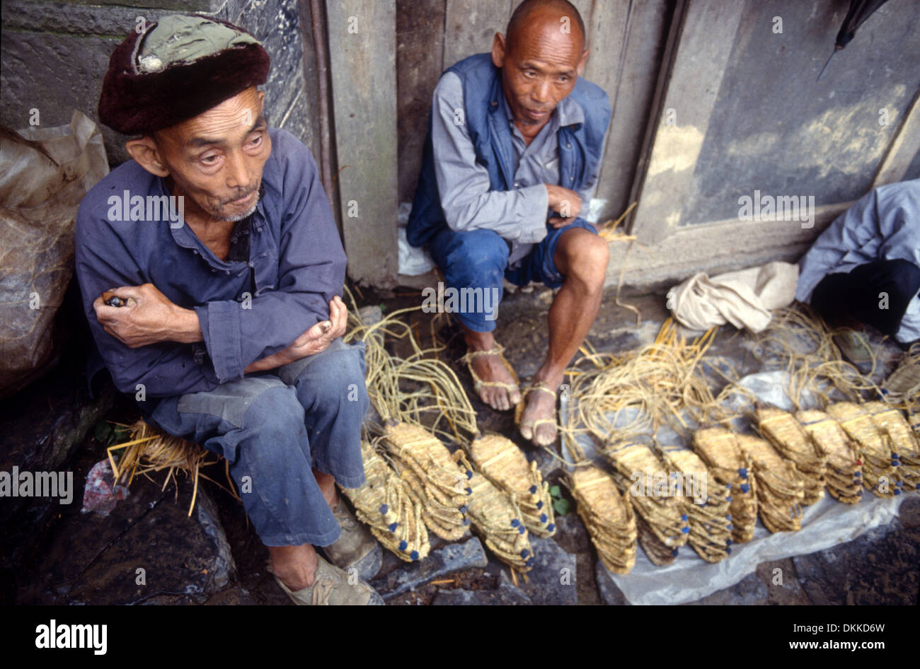 Zwei Männer verkaufen Stroh Schuhe auf einem Markt in der Provinz Hunan, China Stockfoto