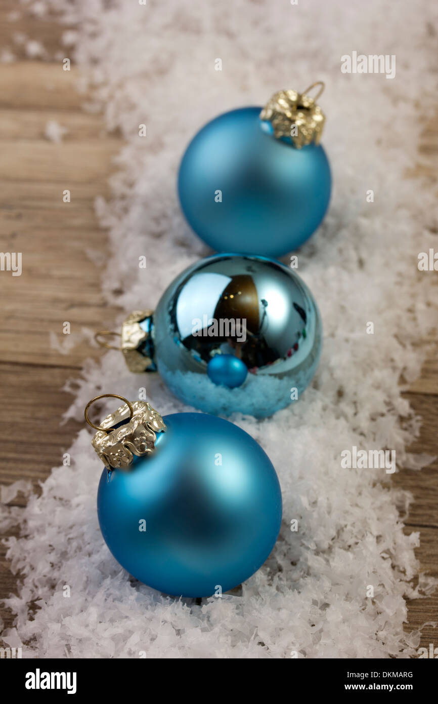 Blaue Weihnachtskugeln im Schnee mit hölzernen Hintergrund Stockfoto