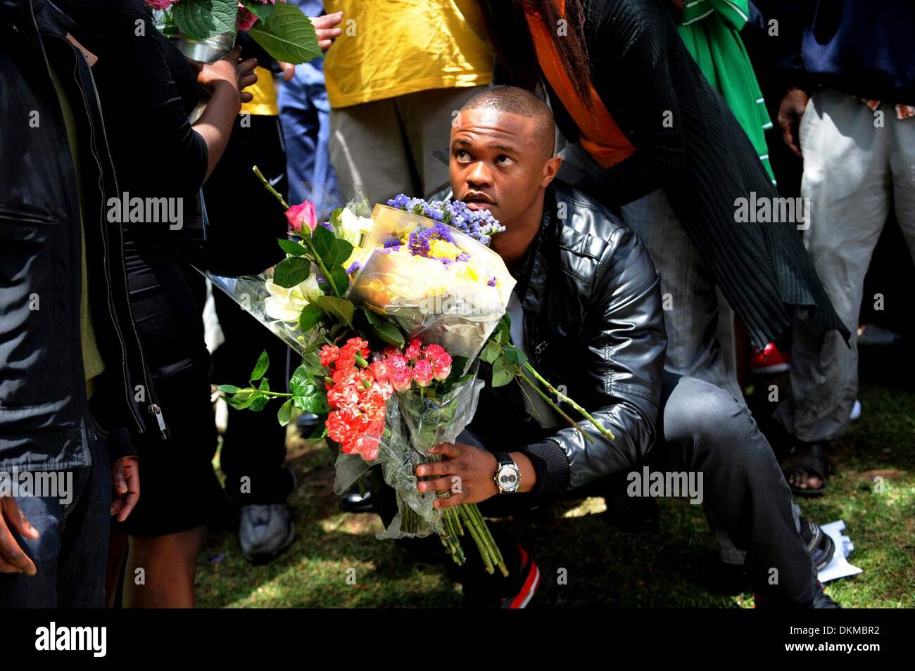 JOHANNESBURG, Südafrika: eines Madiba Enkel sammelt Blumen außerhalb des Hauses Houghton am 7. Dezember 2013, in Johannesburg, Südafrika. Der Vater der Nation, Nelson Mandela, Tata Madiba, ruhig am Abend des 5. Dezember 2013 in seinem Haus in Houghton mit Familie verstorben. (Foto von Gallo Images / Sonntag Welt / Tsheko Kabasia) Stockfoto