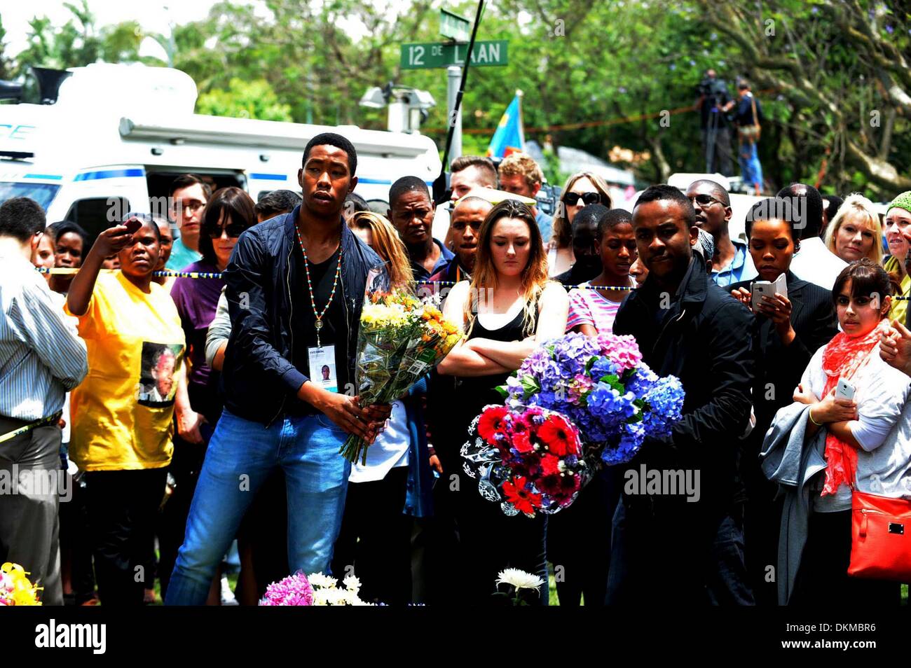 JOHANNESBURG, Südafrika: eines Madiba Enkel sammelt Blumen außerhalb des Hauses Houghton am 7. Dezember 2013, in Johannesburg, Südafrika. Der Vater der Nation, Nelson Mandela, Tata Madiba, ruhig am Abend des 5. Dezember 2013 in seinem Haus in Houghton mit Familie verstorben. (Foto von Gallo Images / Sonntag Welt / Tsheko Kabasia) Stockfoto