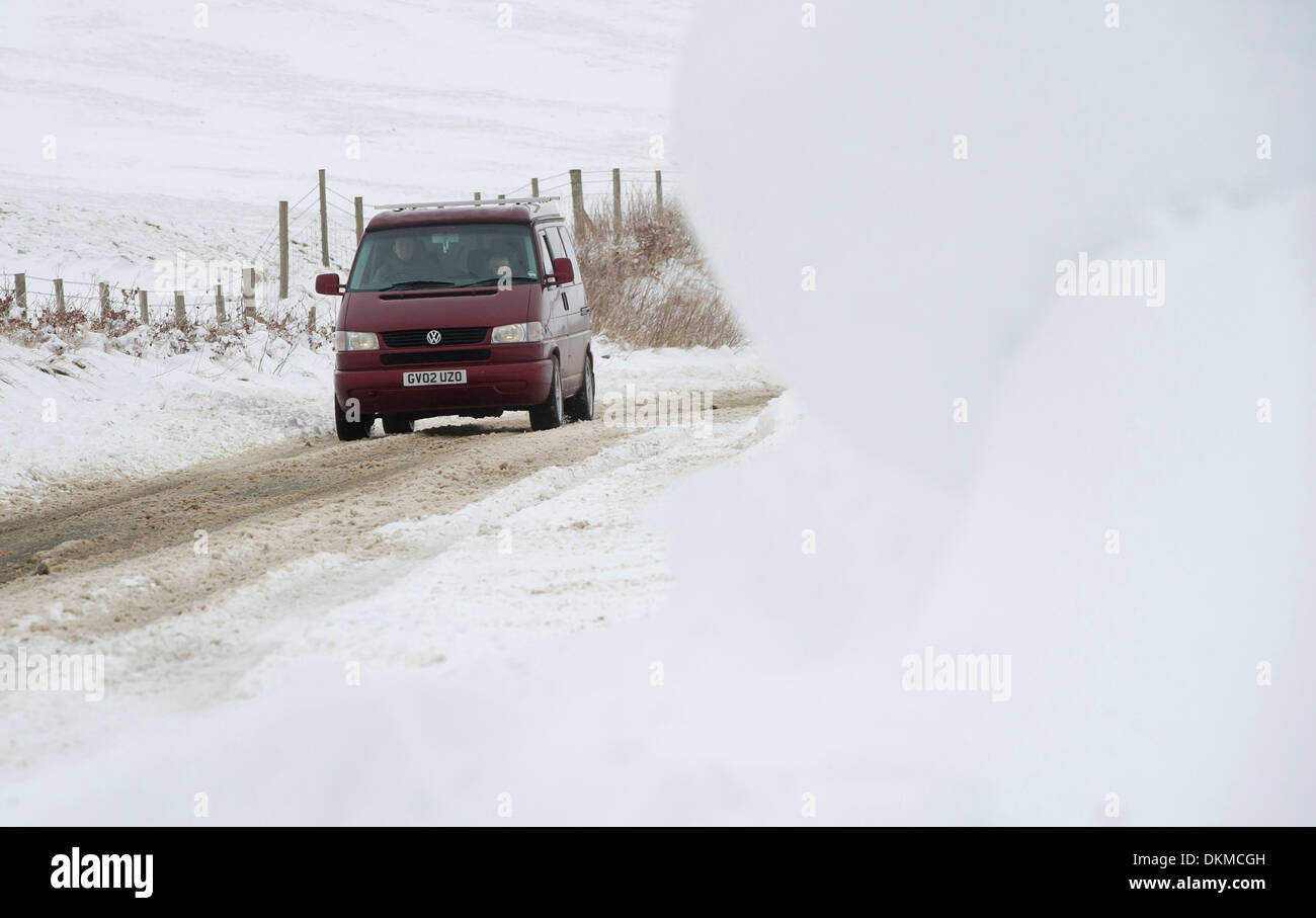 Ein van fährt durch Schneeverwehungen auf Exmoor im Winter, UK Stockfoto