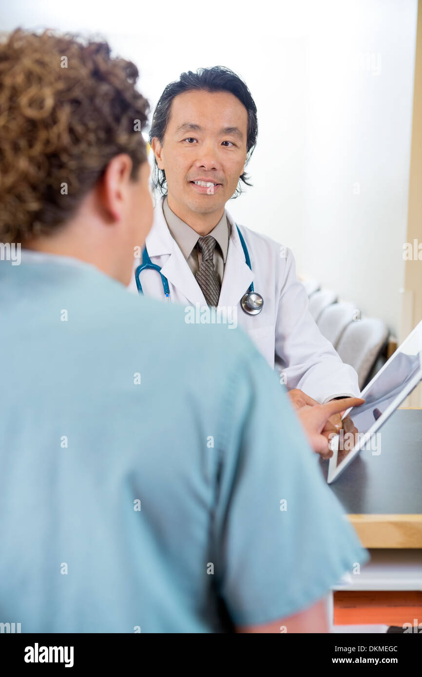 Arzt und Krankenschwester mit Digital-Tablette an der Rezeption Stockfoto