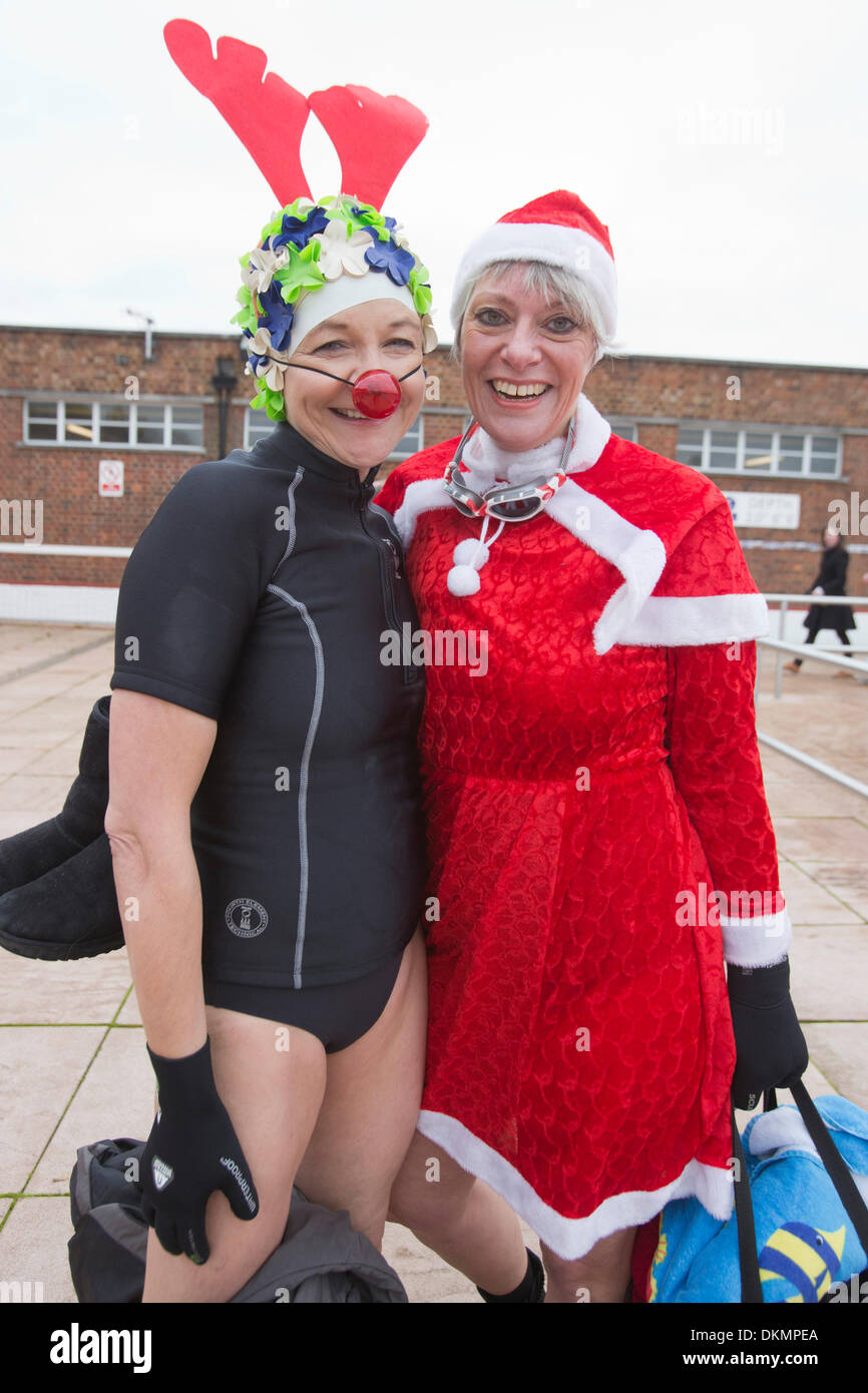 London, UK. 7. Dezember 2013. Frauen mit Rudolf das Rentier und Santa-Outfits vor dem Schwimmen. Mehrere hundert mutige Schwimmer, viele saisonale verkleidet, verspannt die Kälte (Wassertemperatur 6° C, Lufttemperatur 9° C) und nahm einen Sprung auf der Outdoor Swimming Society annual Dezember Dip im Parlament Hill Lido auf North London Hampstead Heath. Foto. Nick Savage/Alamy Live-Nachrichten Stockfoto