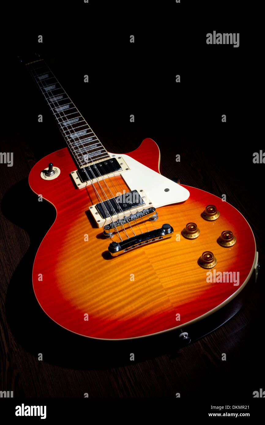 Cherry Sunburst Les Paul Gitarre auf dunklen braunen Holzboden Stockfoto