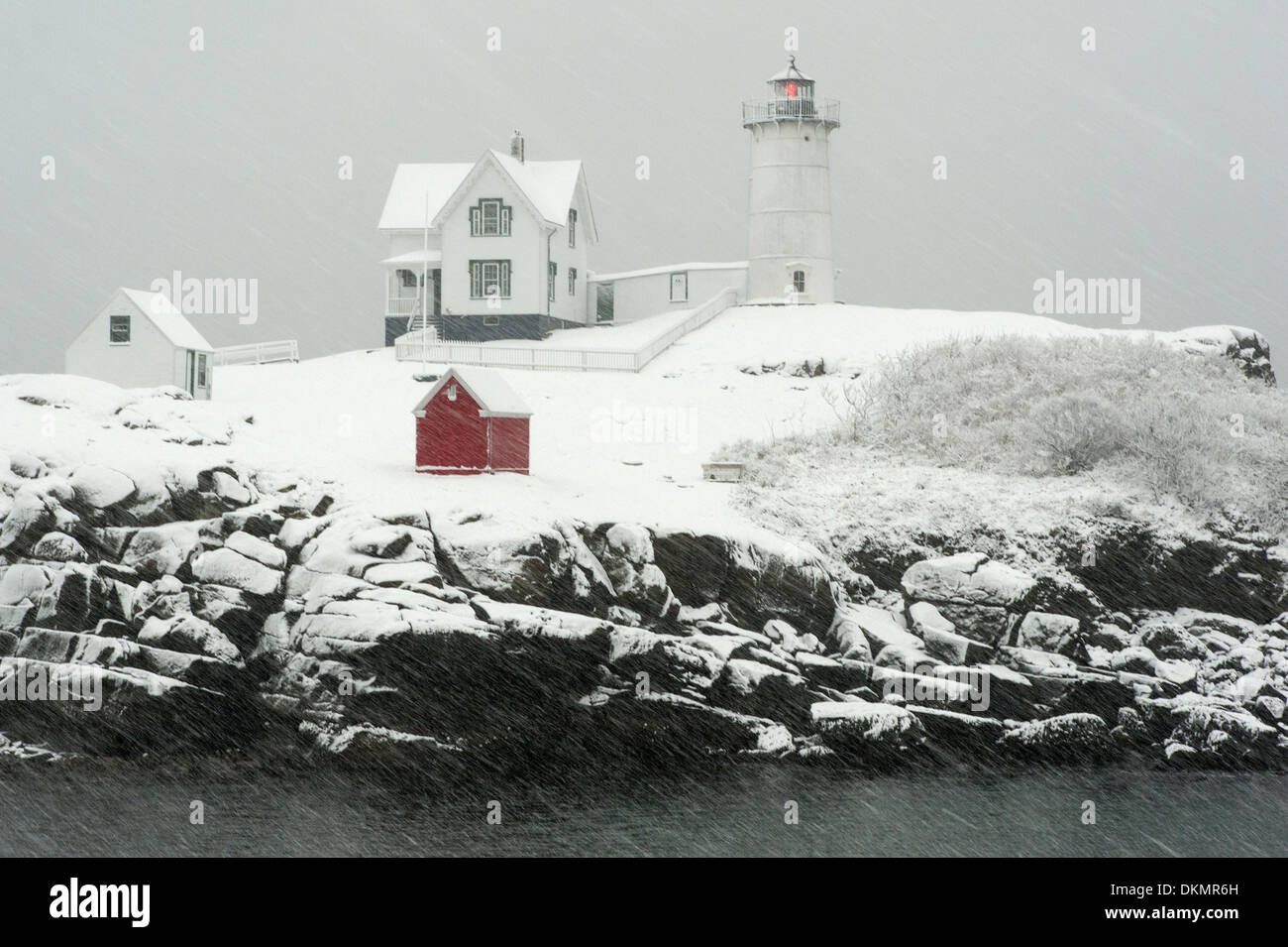 Sofort startbereit (Cape Neddick) Leuchtturm blinkt die rote Lampe bei Schneesturm in Maine. Stockfoto