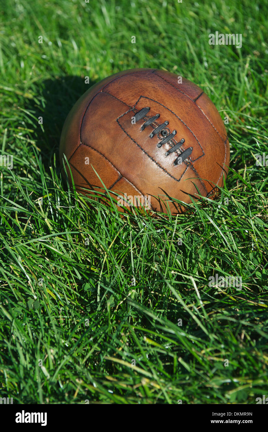 Vintage braun Fußball Fußball sitzt im sonnigen grünen Wiese Stockfoto