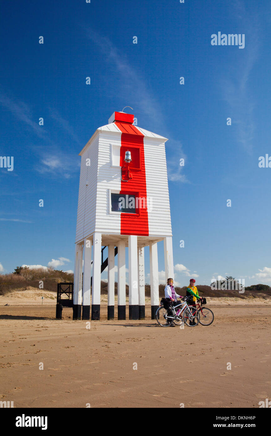 Zwei Radfahrer anhalten am Strand von Burnham auf Meer Somerset England vor dem berühmten hölzernen Leuchtturm Stockfoto