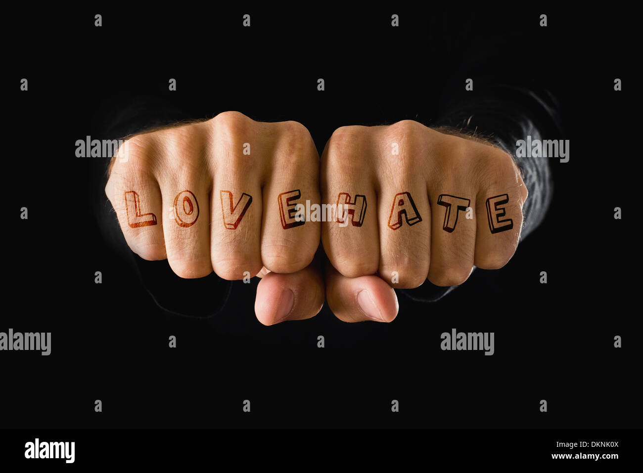 Liebe und Hass Tattoo. Hände mit geballten Fäusten auf dunklem Hintergrund. Kraft, Entschlossenheit, Widerstand-Konzept. Stockfoto