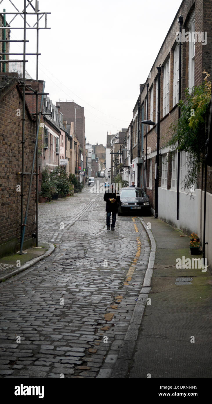 Eine Person zu Fuß entlang Brownlow Mews Guilford Street und Grays Inn Road in London WC1 KATHY DEWITT Stockfoto