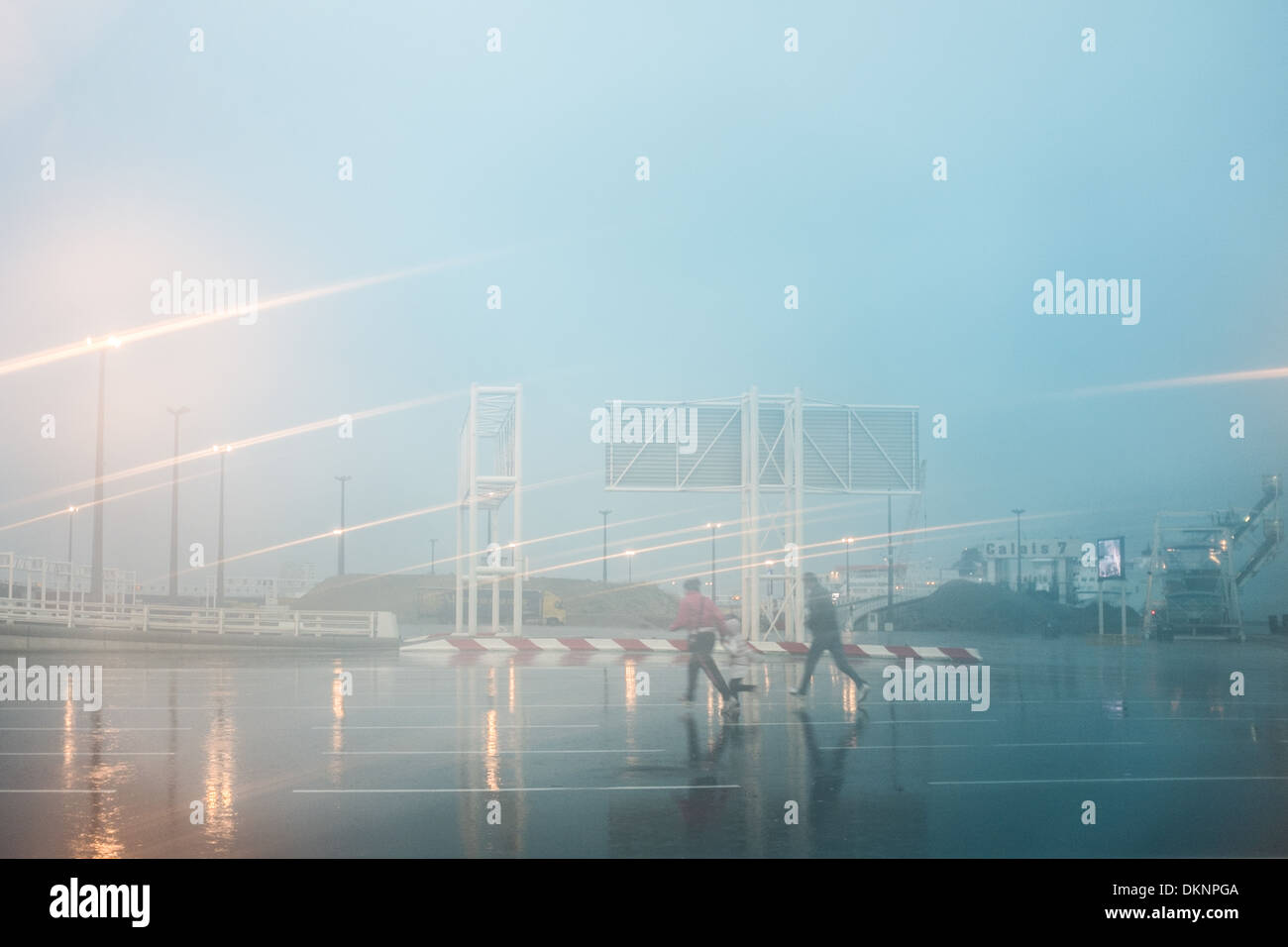 2 Personen Runing im Regen, Hafen von Calais, Frankreich. Stockfoto
