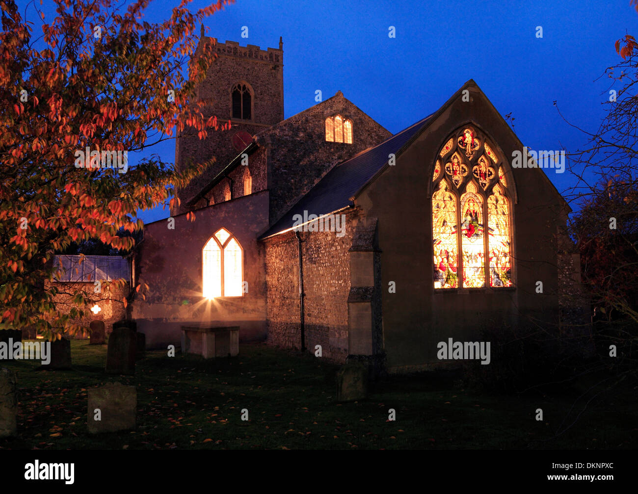 Brancaster Kirche, Ost-Fenster Lichter leuchten durch Glasfenster in der Nacht, Norfolk, England UK Stockfoto