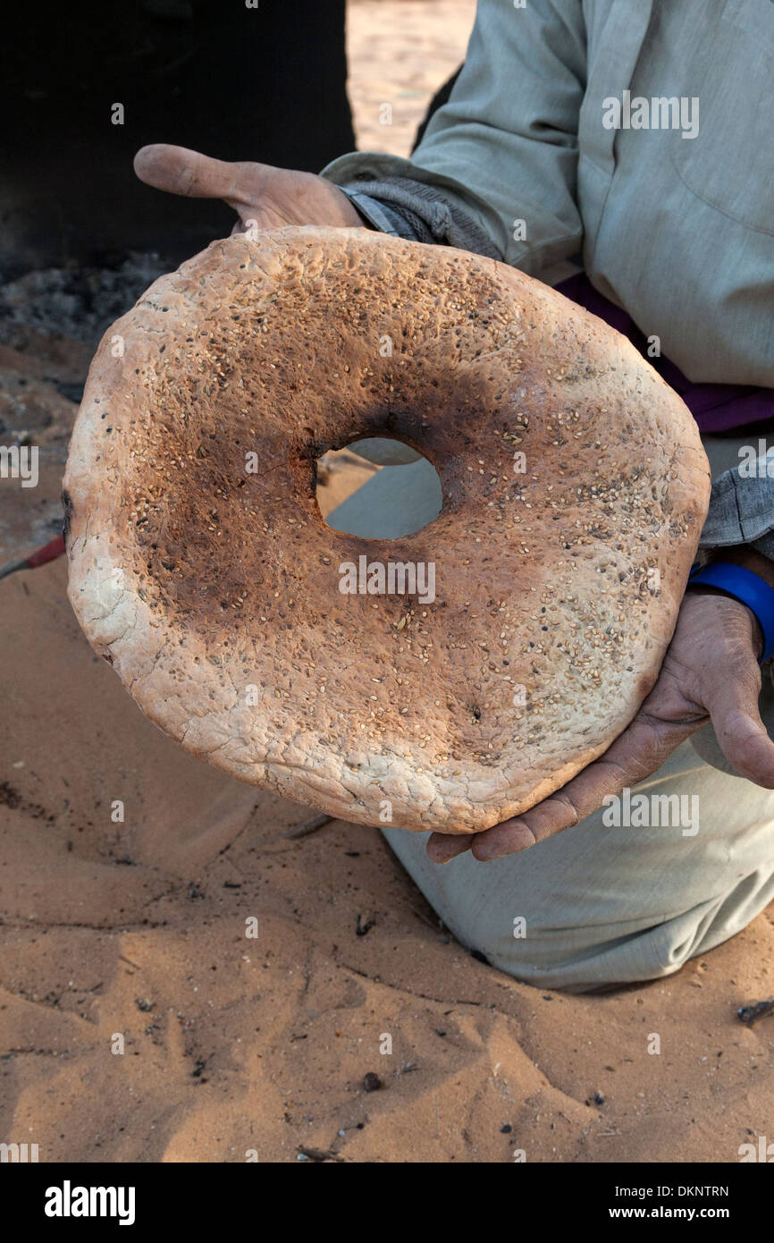 Libyen, Ghadames. Tuareg Mann anzeigen Brot mit Sesam nach dem Backen ...