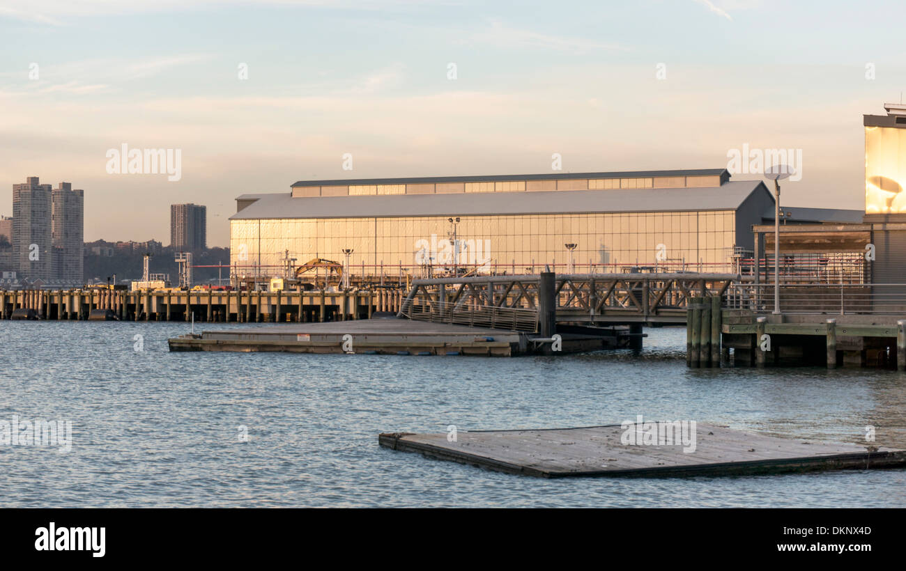 New York City Department of Sanitation Pier in der Dämmerung mit Pier-Neubau im Vordergrund am Hudson River waterfront Stockfoto