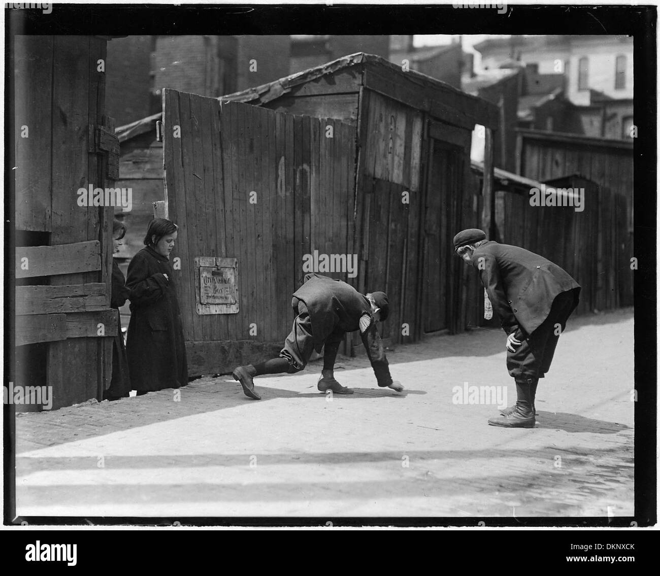 Eine Szene, in der Truants, darunter „Red St. Clair“, um 11:00 UHR an einem Schultag vor Murphy's Branch Würfe schießen, die die Rebellion der Jugendlichen und das soziale Verhalten veranschaulichen. Stockfoto