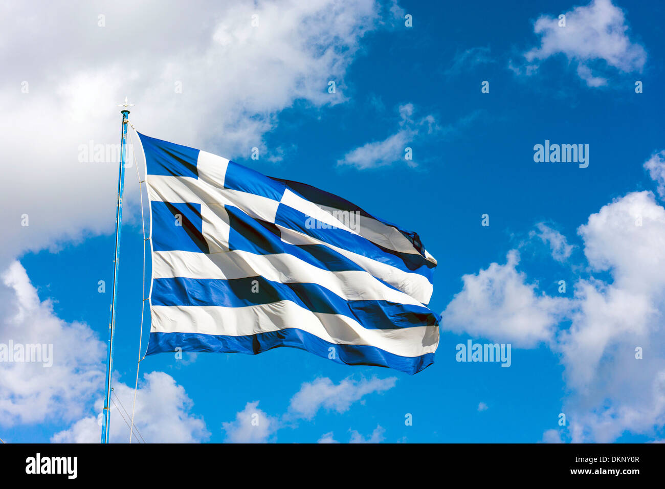 Große griechische Fahne flattert gegen blauen Himmel mit weißen Wolken Stockfoto
