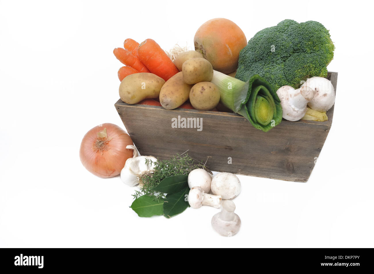 verschiedene Gemüse der Saison in einem hölzernen Korb auf weißem Hintergrund Stockfoto