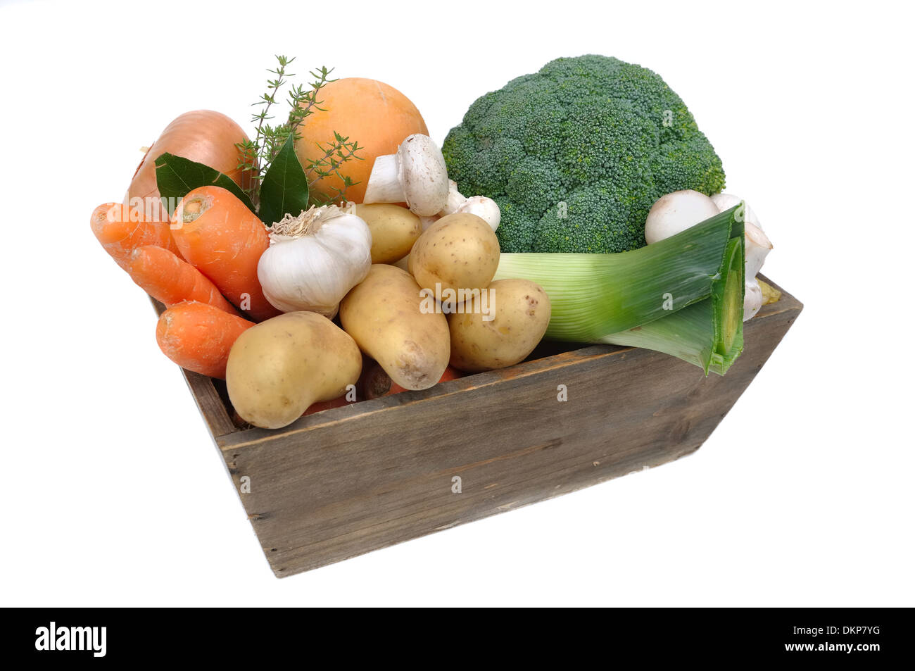 verschiedene Gemüse der Saison in einem hölzernen Korb auf weißem Hintergrund Stockfoto
