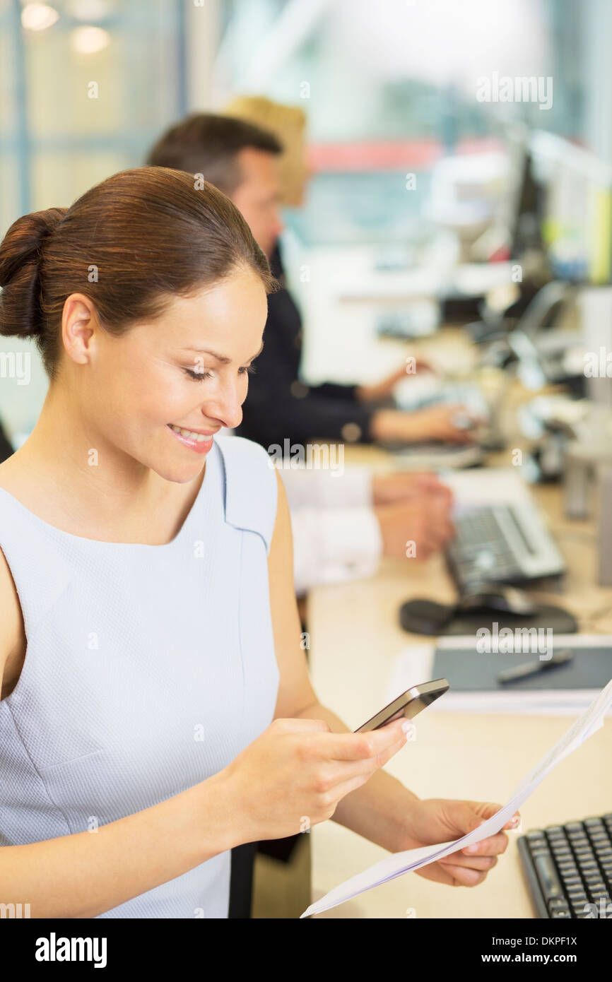 Geschäftsfrau mit Handy im Büro Stockfoto