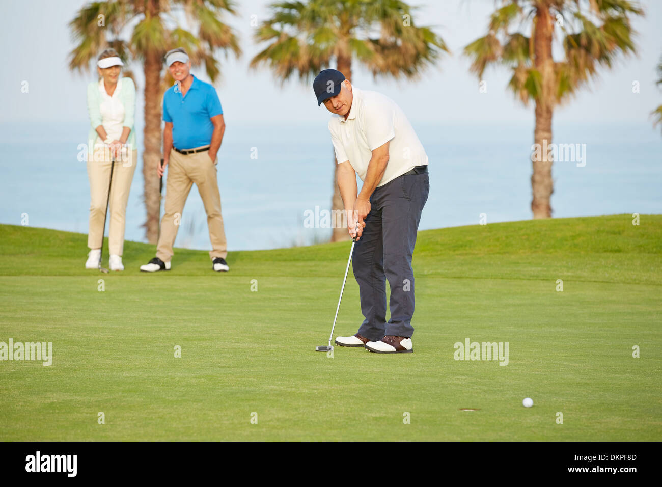 Senioren Freunde spielen Golf auf Kurs Stockfoto