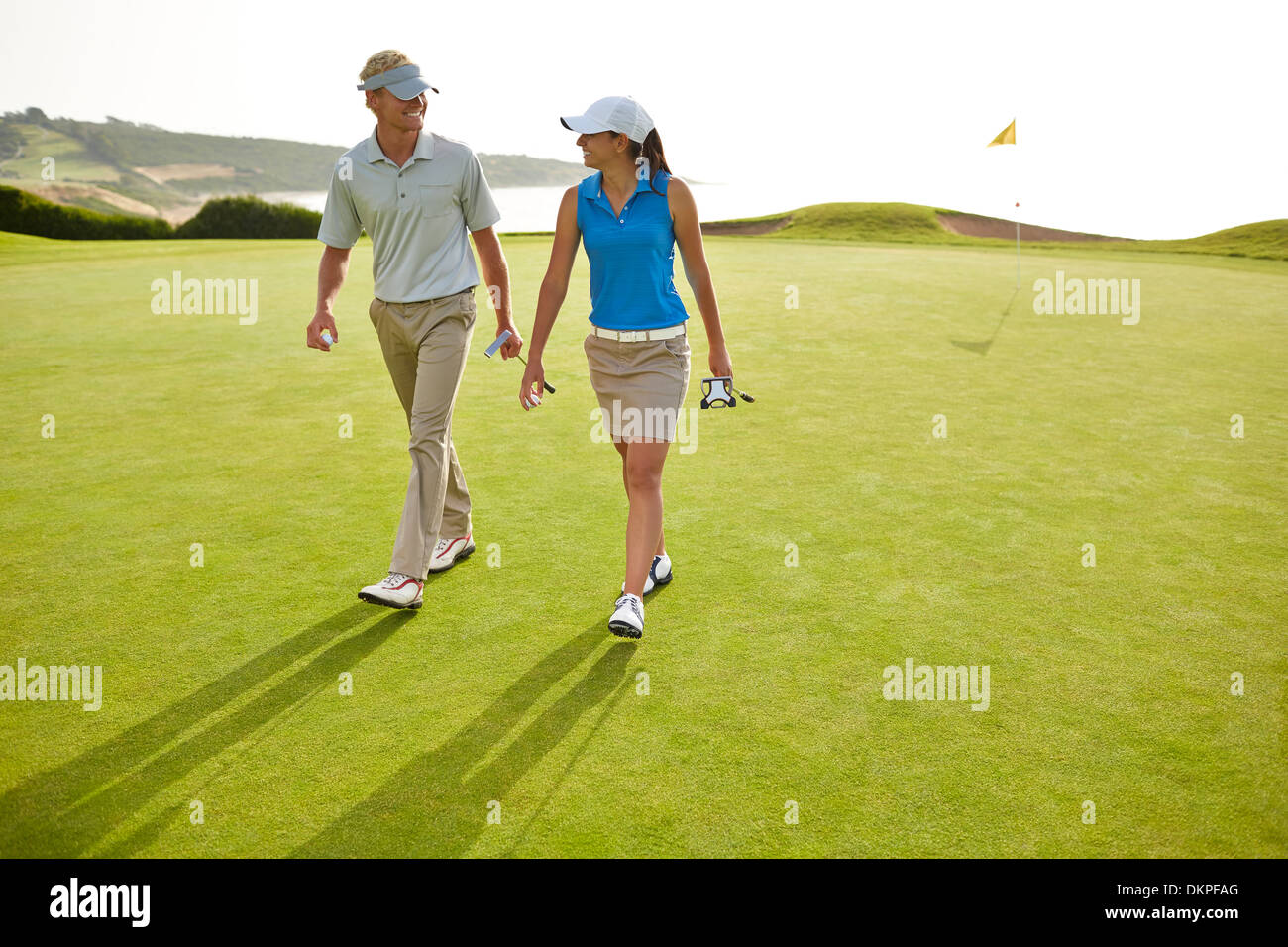 Paare, die auf Golfplatz Stockfoto