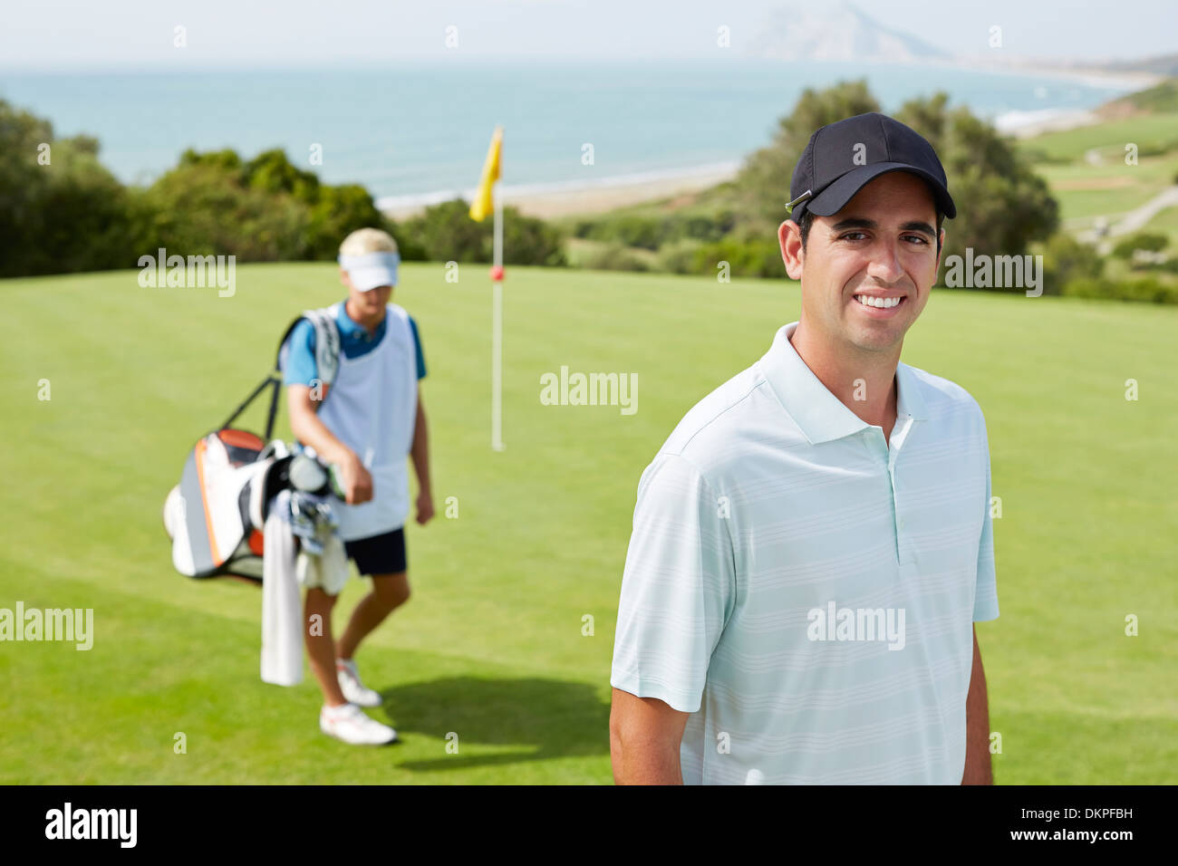 Caddy und Golfer am Golfplatz Stockfoto