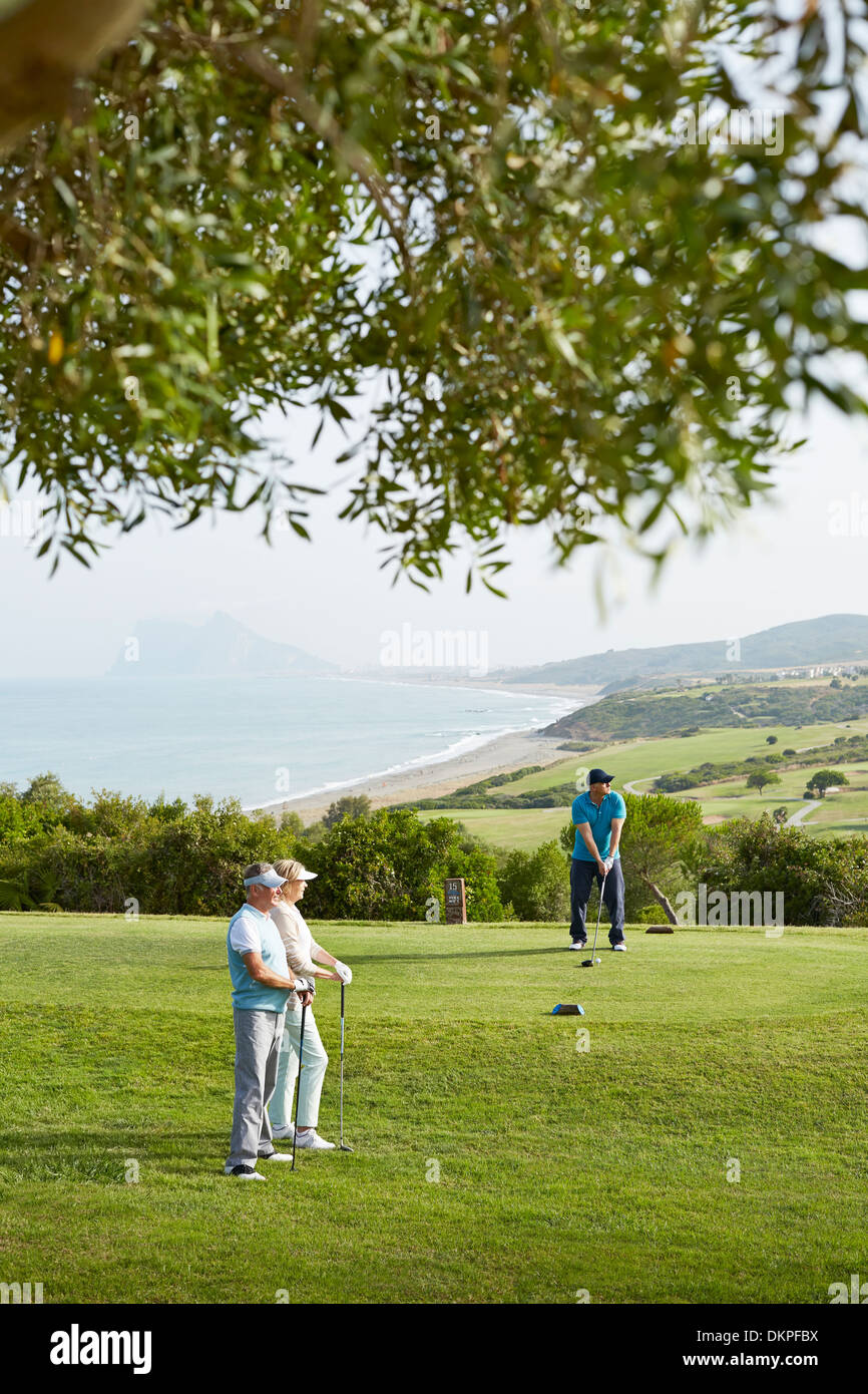 Ältere Freunde spielen Golf auf Kurs Stockfoto